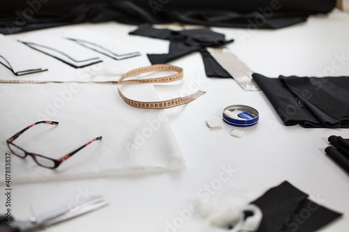 Sewing accessories and fabric on a white background. Sewing threads, needles, pins, fabric, buttons and sewing centimeter. top view, flatlay