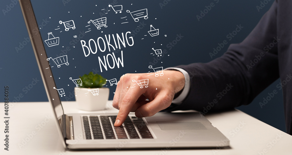 Businessman working on laptop with BOOKING NOW inscription, online shopping concept Businessman working on laptop with BOOKING NOW inscription, online shopping concept