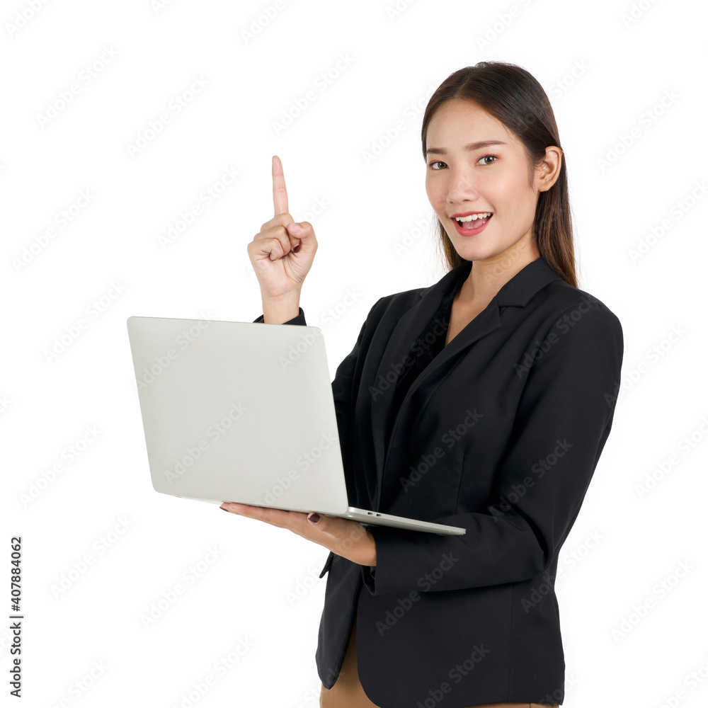 Young asian businesswoman in a black suit holding a laptop computer pointing one finger in upward direction. Portrait on white background with studio light. Young asian businesswoman in a black suit holding a laptop computer pointing one finger in upward direction. Portrait on white background with studio light.
