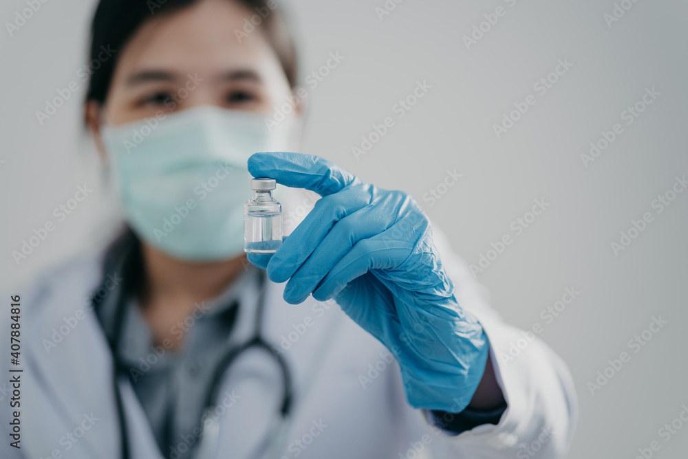 female doctor, scientist, researcher is showing syringe and vaccine vial with medication, closeup. Vaccination and immunization female doctor, scientist, researcher is showing syringe and vaccine vial with medication, closeup. Vaccination and immunization