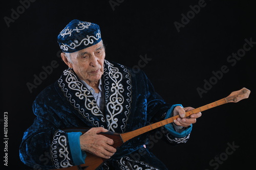 Kazakh old man playing dombra photo