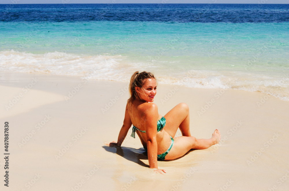 Smiling woman in bikini on tropical beach