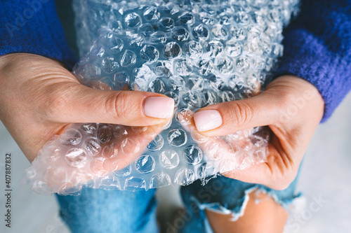 Woman hands squeezing or popping bubbles in bubble wrap. Anti stress, relax concept