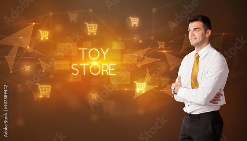 Businessman with shopping cart icons and TOY STORE inscription, online shopping concept