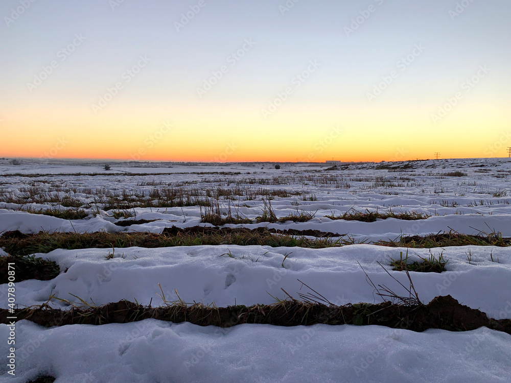 Snow covered cultivation fields at sunset Snow covered cultivation fields at sunset