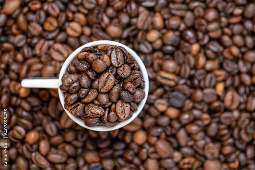 Fototapeta premium coffee beans close up and a cup full of coffee beans, top view