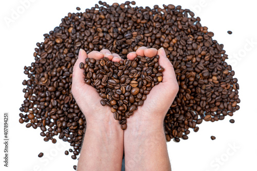 coffee beans close-up on the palm in the shape of a heart against the background of other coffee beans