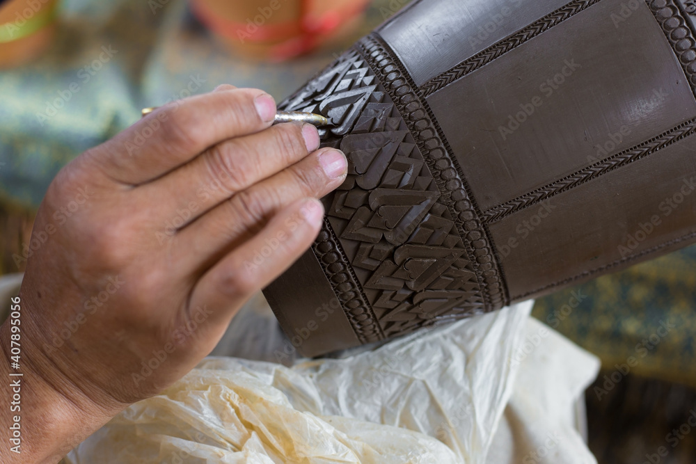 Fototapeta premium Clay carving is a Thai Traditional to made earthenware. Handcrafted Carved Pottery Jar.