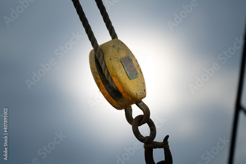 Old wooden pulley and metal hook mountain on a classical sailboat. photo