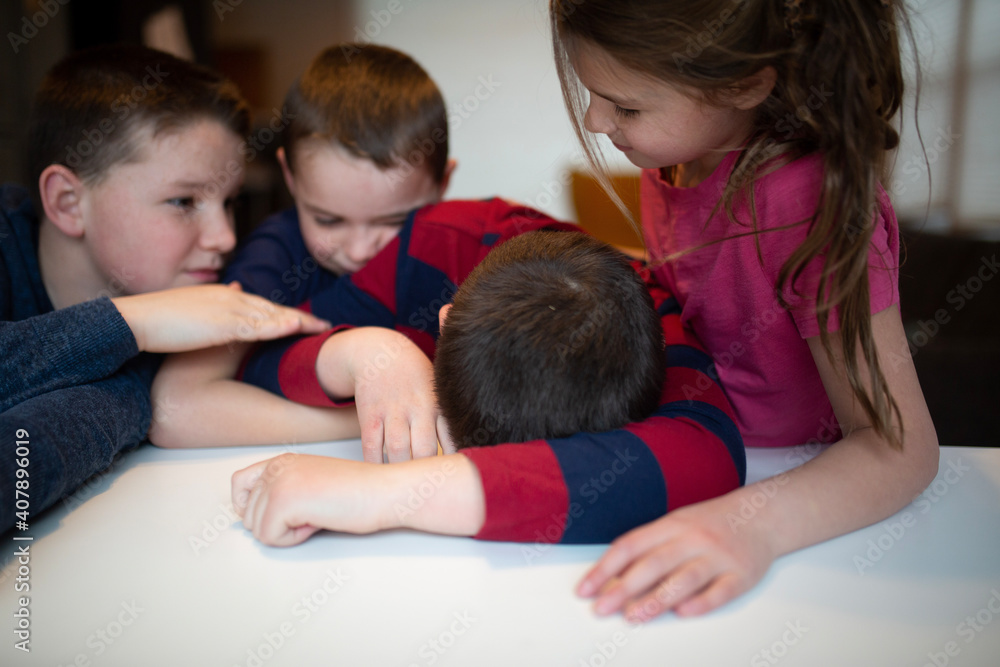 sad boy being comforted by siblings sad boy being comforted by siblings