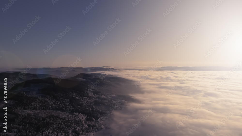 Fog and clouds in a valley at sunset in a wilderness winter wonderland.