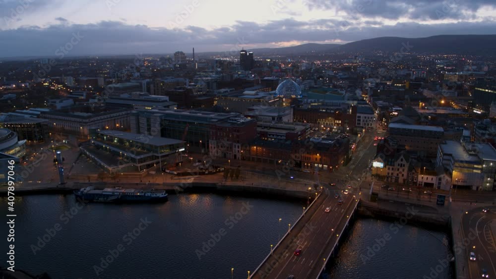 Belfast, Northern Ireland. City centre aerial flyover at dusk and during the night. River Lagan, City Hall, Victoria Square, Lagan Weir