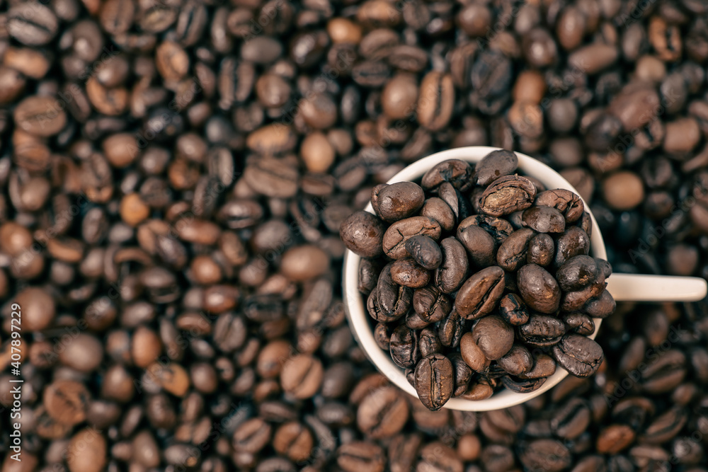 Fototapeta premium coffee beans close up and a cup full of coffee beans, top view