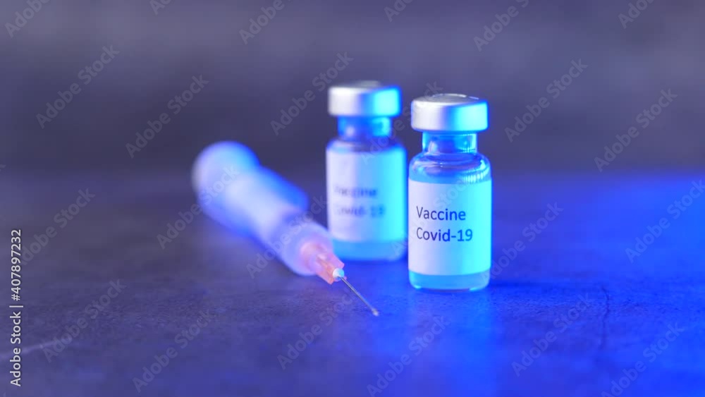 Close up of coronavirus vaccine and syringe on black background Close up of coronavirus vaccine and syringe on black background