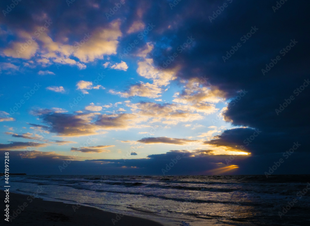 Fototapeta premium sunset on the beach with stormy sky.