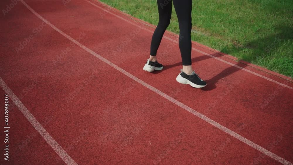 young male or female workout with side step running on race track at summer young male or female workout with side step running on race track at summer