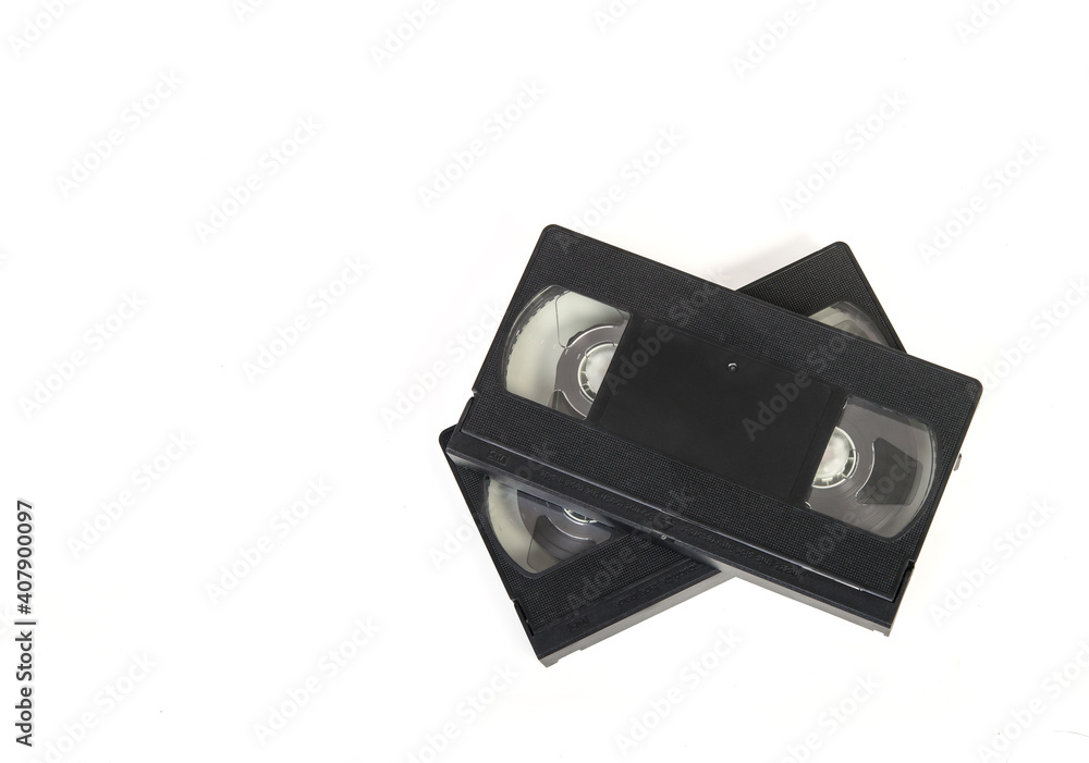 Dos cintas de vídeo aisaladas sobre fondo blanco. Imágen horizontal de los objetos de color negro. Vista desde arriba con espacio de copia.