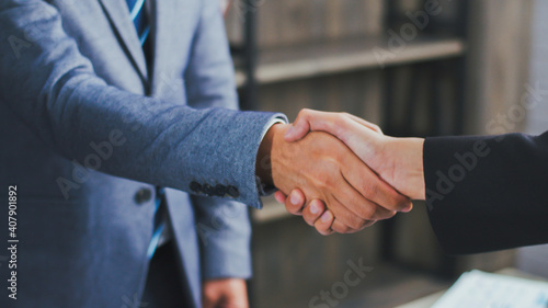 Asian businessman shaking hands partnership deal business while standing indoors in the office, Happy confident Asian boss accept handshaking employer getting hired at a new job.