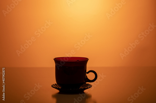 Cup and saucer in the shade. Backlit cup.