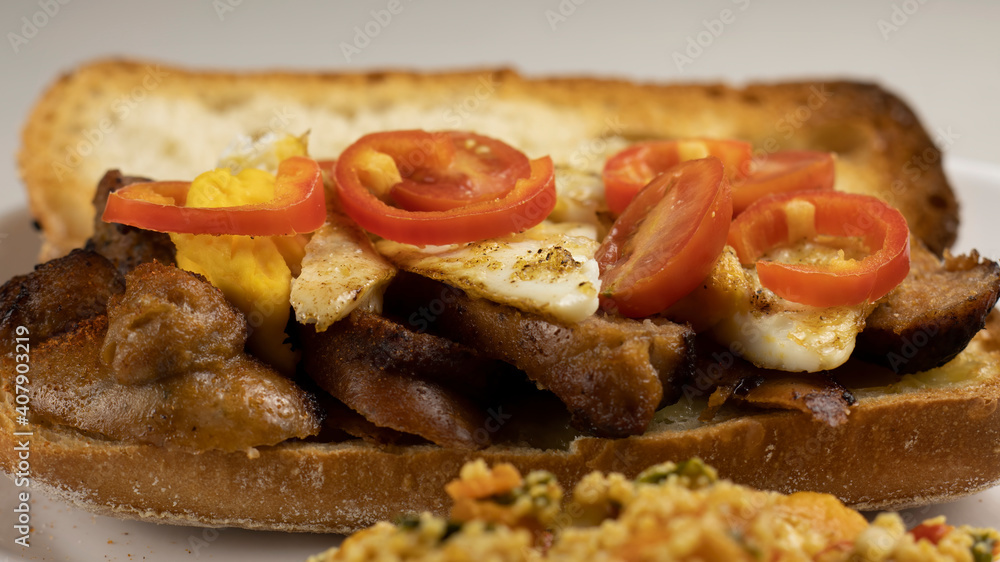 Grilled Meat Sausages on Ciabatta Bread topped with some Eggs and Red Pepper.