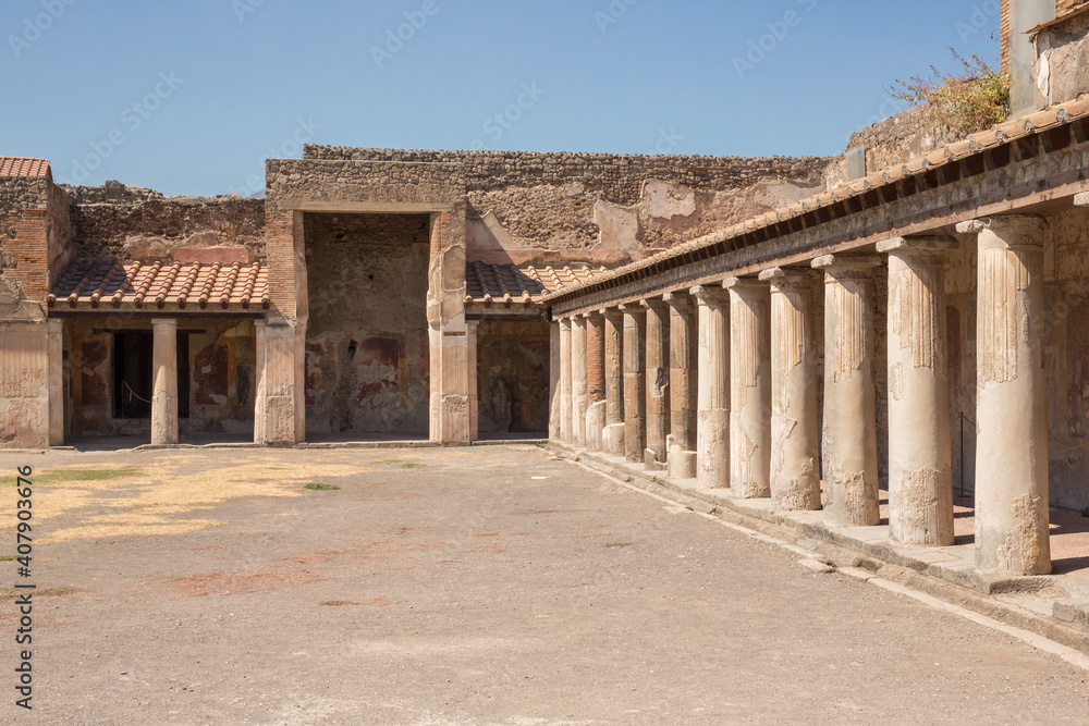 The remains of the ancient Roman city of Pompeii. On the background the volcano Vesuvius.