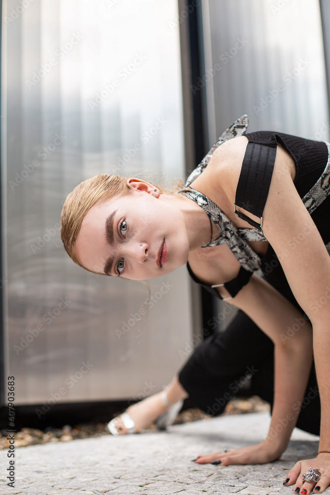 Fototapeta premium White girl in black clothes sitting in city lane
