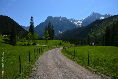 Gravel road leading into mountains. Spring in Austrian mountains