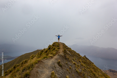 A manlooking at the beautiful landscape of the mountains and Lake Wanaka. Roys Peak Track  South Island  New Zealand