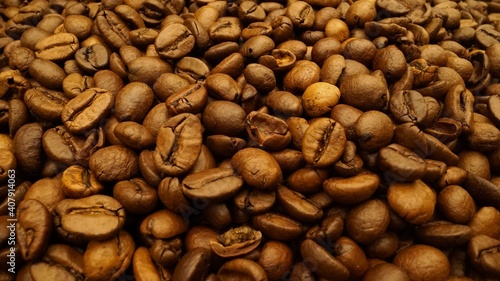 Close-up frame of hands take coffee beans. Sorting coffee beans. The black coffee beans are spinning.