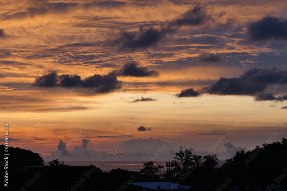 Phuket, Thailand, October 02, 2018: Dramatic sunset with scattered clouds floating over the waters of the Andaman Sea and the forests on the shore of Phuket. Phuket, Thailand, October 02, 2018: Dramatic sunset with scattered clouds floating over the waters of the Andaman Sea and the forests on the shore of Phuket.