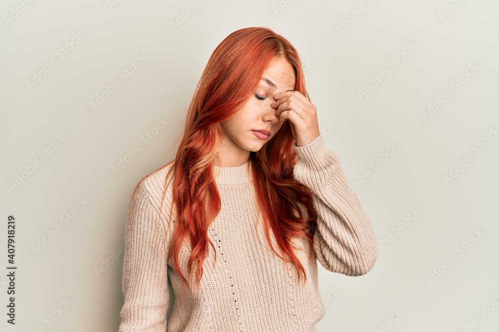 Young beautiful redhead woman wearing casual winter sweater tired rubbing nose and eyes feeling fatigue and headache. stress and frustration concept. Young beautiful redhead woman wearing casual winter sweater tired rubbing nose and eyes feeling fatigue and headache. stress and frustration concept.