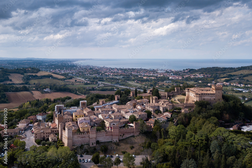 Italy - aerial view of the medieval village of Gradara in the province of Pesaro and Urbino in the Marche region. In the background the Romagna Riviera and the Adriatic Sea