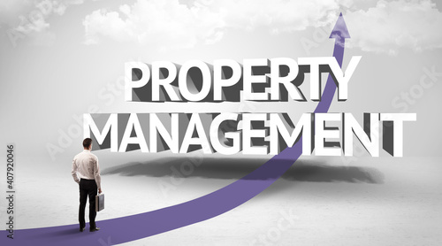 Rear view of a businessman standing in front of PROPERTY MANAGEMENT inscription, successful business concept © ra2 studio