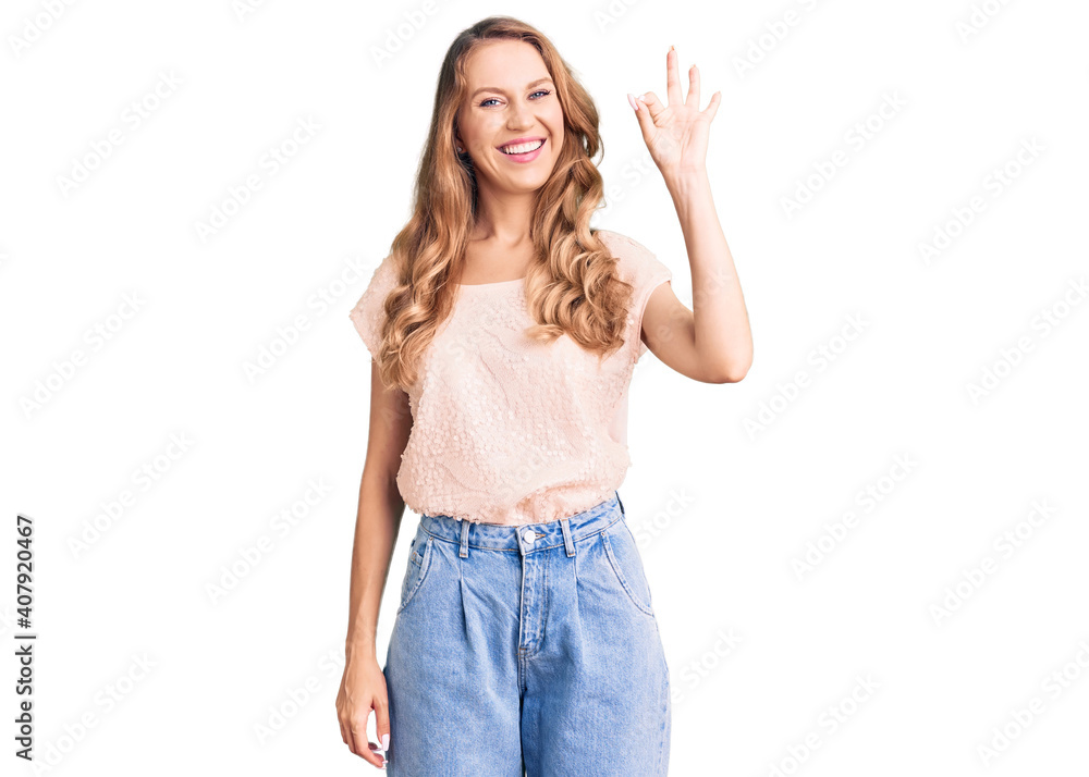 Young beautiful caucasian woman with blond hair wearing casual clothes smiling positive doing ok sign with hand and fingers. successful expression. Young beautiful caucasian woman with blond hair wearing casual clothes smiling positive doing ok sign with hand and fingers. successful expression.