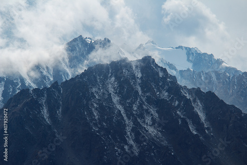 Fényképezés Mountain snowy peaks with clouds on a sunny day