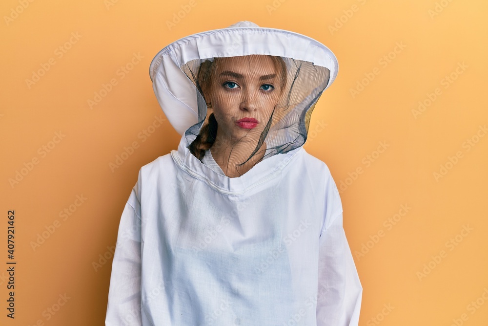 Beautiful blonde caucasian woman wearing protective beekeeper uniform depressed and worry for distress, crying angry and afraid. sad expression. Beautiful blonde caucasian woman wearing protective beekeeper uniform depressed and worry for distress, crying angry and afraid. sad expression.