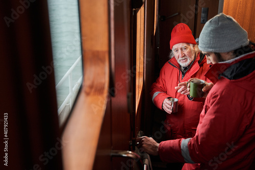 Man relaxing after work with his smiling male colleague