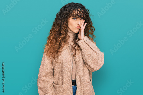 Young hispanic girl wearing winter clothes touching mouth with hand with painful expression because of toothache or dental illness on teeth. dentist