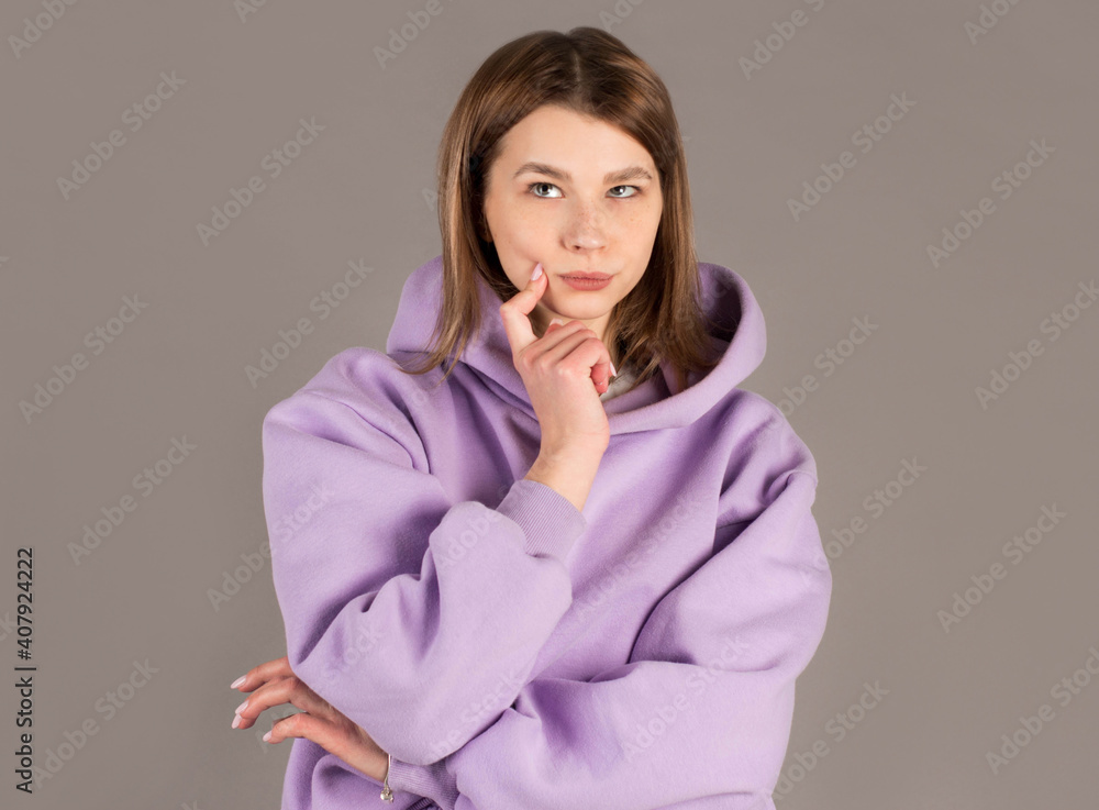 Hesitant thoughtful young female holds chin, curves lips, has dark healthy skin, wears striped sweater, looks puzzled aside, contemplates about something, poses over gray wall Hesitant thoughtful young female holds chin, curves lips, has dark healthy skin, wears striped sweater, looks puzzled aside, contemplates about something, poses over gray wall