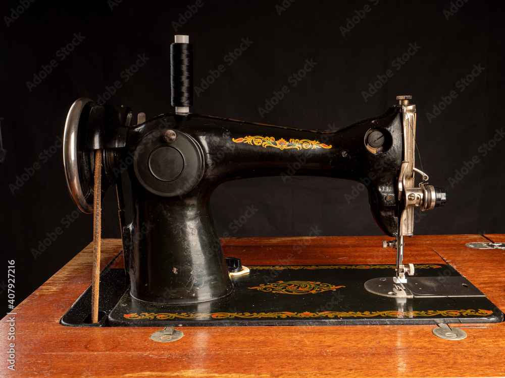 Soviet black sewing machine on a wooden stand close-up