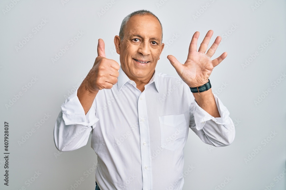 Handsome senior man wearing casual white shirt showing and pointing up with fingers number six while smiling confident and happy. Handsome senior man wearing casual white shirt showing and pointing up with fingers number six while smiling confident and happy.