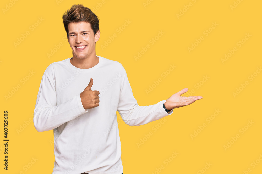 Handsome caucasian man wearing casual white sweater showing palm hand and doing ok gesture with thumbs up, smiling happy and cheerful Handsome caucasian man wearing casual white sweater showing palm hand and doing ok gesture with thumbs up, smiling happy and cheerful