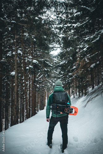 winter landscape forest backpack man / traveler in modern winter clothes in the forest, traveling in the mountains photo