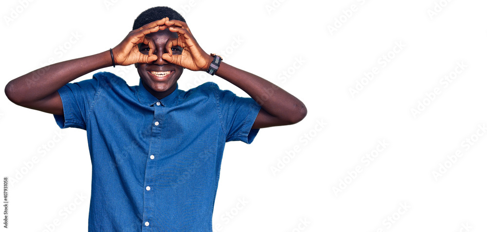 Young african american man wearing casual clothes doing ok gesture like binoculars sticking tongue out, eyes looking through fingers. crazy expression. Young african american man wearing casual clothes doing ok gesture like binoculars sticking tongue out, eyes looking through fingers. crazy expression.