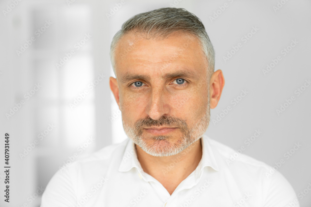 Obraz premium Bearded middle-aged man looking at camera with a serious expression