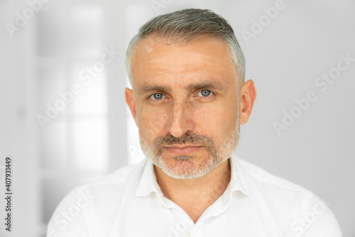 Bearded middle-aged man looking at camera with a serious expression