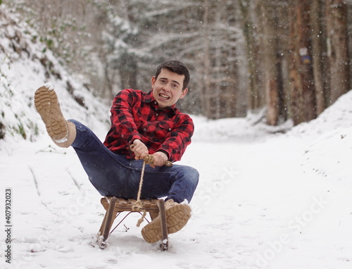 Man riding a sleigh with frightened and anxious face, fear of falling off the sledge - it's getting to fast photo