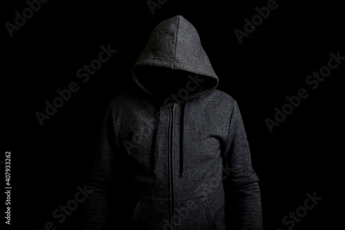 Man without a face in a hood on a dark background