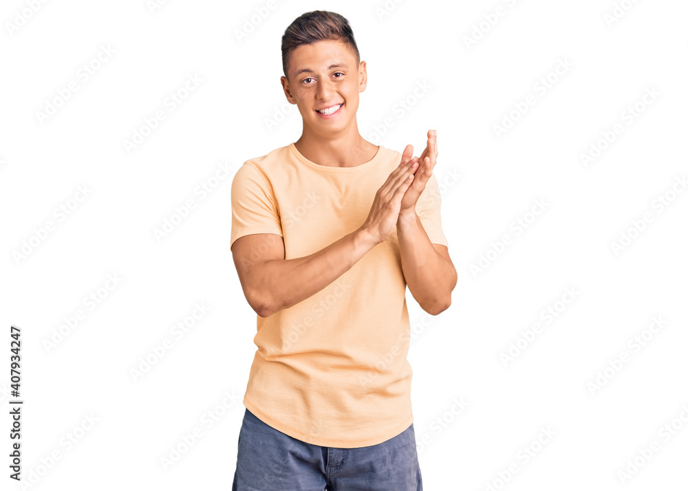 Young handsome man wearing casual clothes clapping and applauding happy and joyful, smiling proud hands together Young handsome man wearing casual clothes clapping and applauding happy and joyful, smiling proud hands together