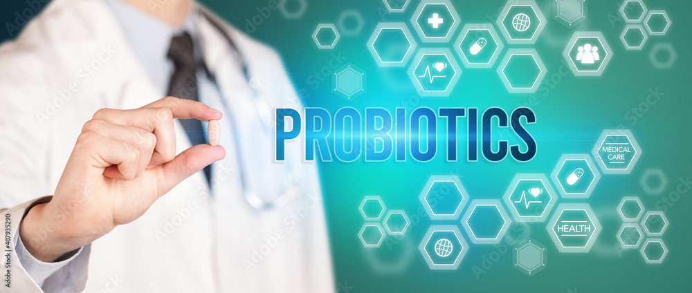 Close-up of a doctor giving you a pill with PROBIOTICS inscription, medical concept Close-up of a doctor giving you a pill with PROBIOTICS inscription, medical concept